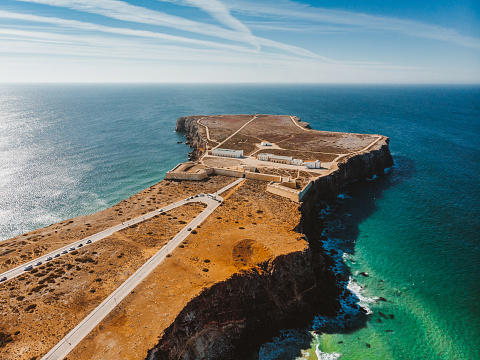 Sagres Fortress – Fortaleza de Sagres and the Church of Our Lady of Grace – Igreja de Nossa Senhora da Graça, Portugal as seen from the drone view. Henry the Navigator ordered the construction of this fortress to protect the strategic coastal position at Ponta de Sagres, and the coves that sheltered shipping.
