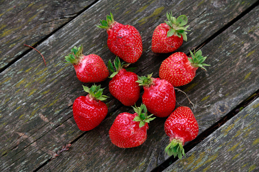 Close-up of ripe strawberries on the wooden surface, view from above