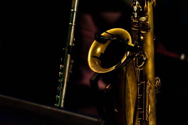 istock Saxophone and flute, stage close up in low key, black isolated 1283231304