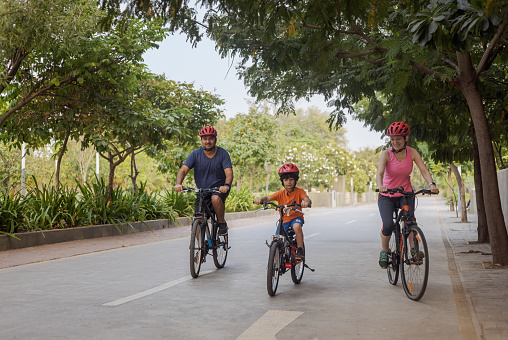Indian father,  Iranian mother cycling with their 5 year old Indian-Iranian boy