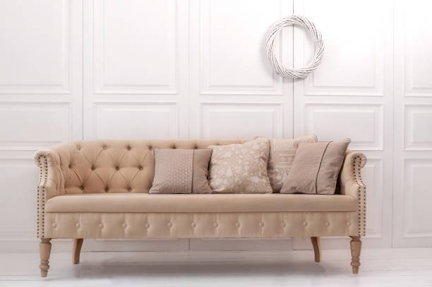 istock Luxury design elements: beige cushions with Christmas pattern on beige old style couch in white room 1283232931