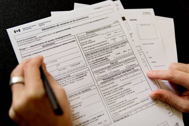 Man hand filling french canadian tax papers. stock photo