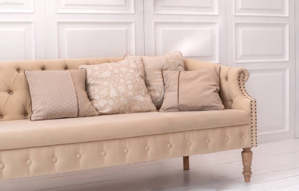 istock Interior design elements: beige cushions with Christmas pattern on beige old style couch in white room 1283234783