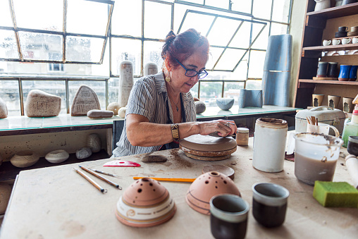 Portrait of senior female pottery artist working with clay