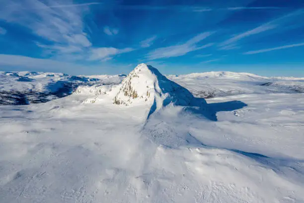 Photo of Remote Aerial drone photo of Atoklimpen - standalone big mountain in Hemavan - Tarnaby area in Scandinavia, Lapland, cold sunny day, blue sky, wild subarctic nature, winter time