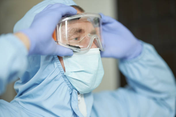 istock Sanitary worker in mask adjusting safety glasses 1283238530