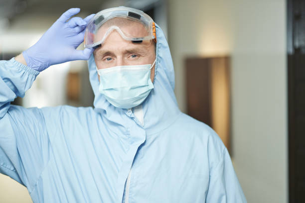 istock Man wearing a protective mask, gloves and suit before disinfection 1283238567