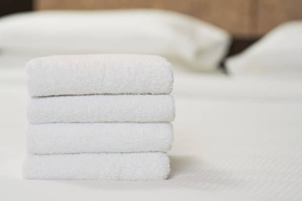 istock White clean towels stacked on bed in bedroom 1283239357