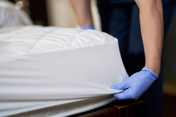 istock Housekeeper in gloves changing bedding in hotel room 1283239606