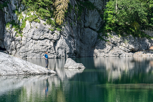 One Mature women standing at the Black Lake in Triglav National Park and enjoying the view.