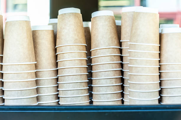 istock Vertical piles of white or beige paper instant cups up side down, standing on table or plate of coffee machine 1283243737