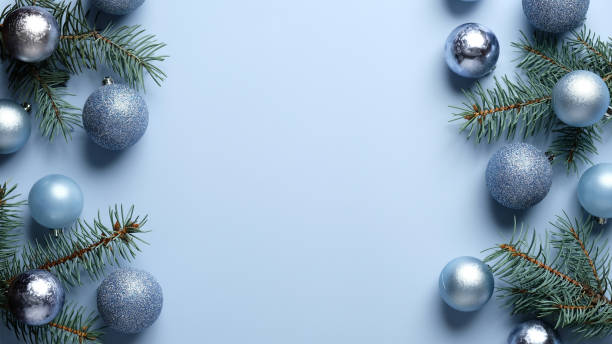 istock Blue Christmas background with pine tree branches and shiny balls decoration. Xmas frame, greeting card template, banner mockup. Flat lay, top view, copy space. 1283245546