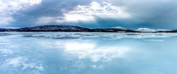 panorama över frusen sjö i norra bergen börjar smälta och vatten strömmar på isytan. joesjosjön i lappland, norra sverige. reflektion av blå himmel och solstrålar i smält isvatten - fjäll sjö sweden bildbanksfoton och bilder