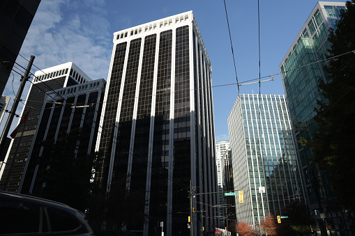 Vancouver, Canada - October 31, 2020: Tall office towers line Burrard Street at West Pender Street in the central business district. Low angle view on an autumn morning.