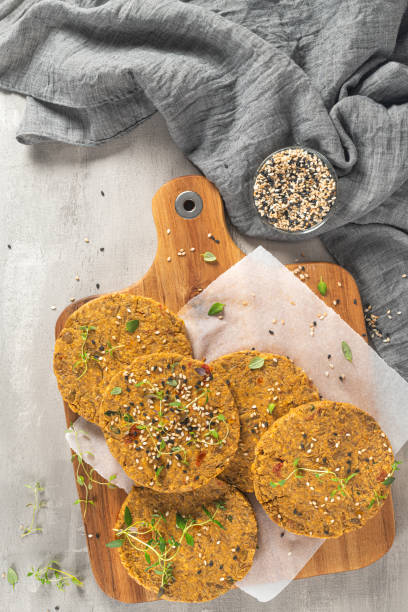 istock Raw veggie burger with lentils, vegetables and thyme leaves on kitchen countertop. Top view. Flat lay 1283247307