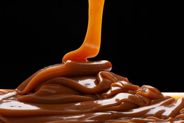 ドゥルセ・ド・レッシュは、黒い背景にバックライトでベースにこぼれました。 - dessert sweet food brown chocolate ストックフォトと画像