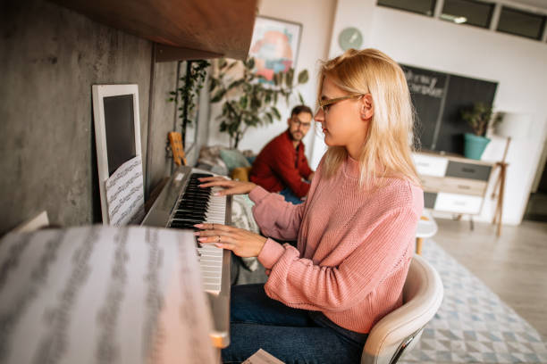 istock Woman playing digital piano and singing at home 1283248323