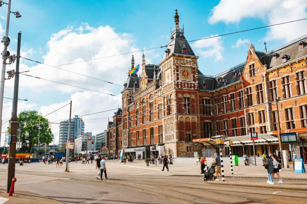 August 1st, 2020 – Amsterdam, Netherlands: Amsterdam Centraal Railroad Station is one of the most beautiful sights in Amsterdam. The Renaissance Style is typical for its time of building – usually it is way more crowded but due to the lockdowns you can see almost empty streets compared to the busy city of Amsterdam. Yes, you can see a pride flag waving above the main entrance hall