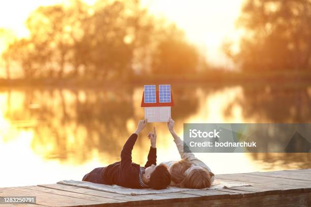 Glückliches Kinderpaar Träumt Von Einem Haus Mit Sonnenkollektoren Stockfoto und mehr Bilder von Sonnenkollektor