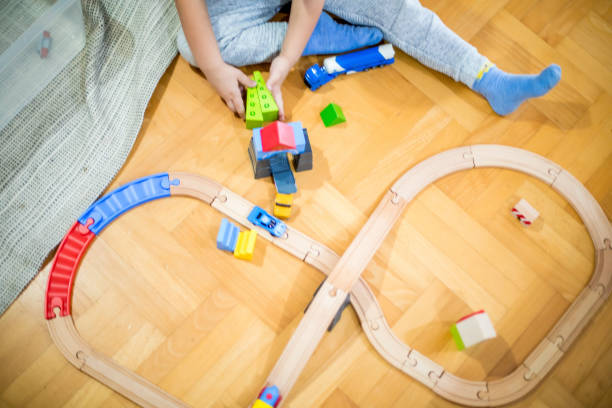 istock Unknown little boy playing with a railroad train toy. 1283250930