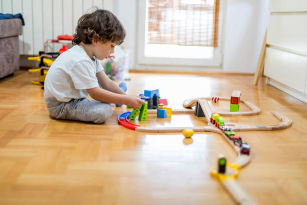 istock Beautiful little boy playing with a railroad train toy. 1283250932