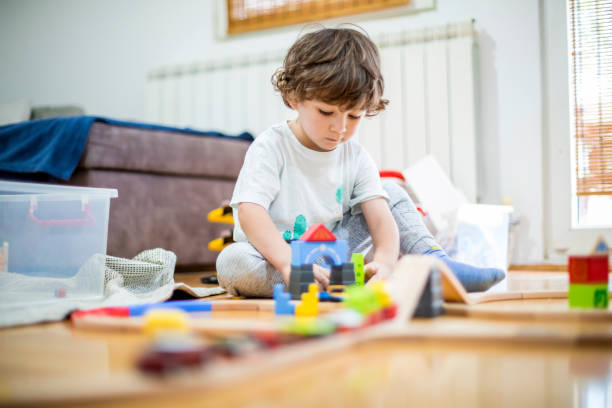 istock Beautiful little boy playing with a railroad train toy. 1283250951