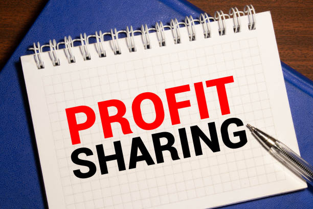 istock Office desk with a paper written PROFIT SHARING with pen 1283251876