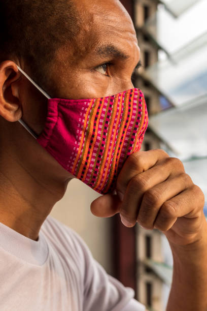 istock A red cloth mask on the face, looking through the louvers. 1283251878