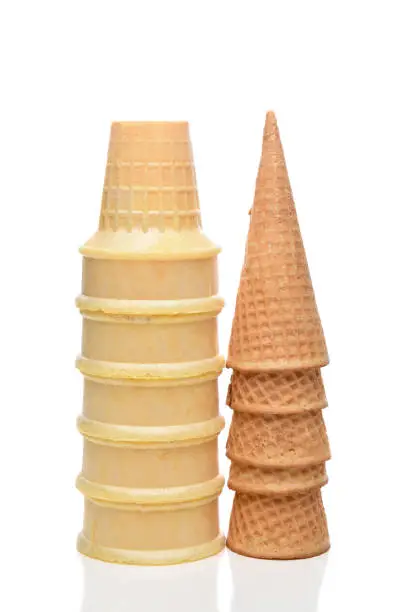 Two stacks of different Ice Cream Cones on white. Sugar cones and wafer of cake cones are represented.