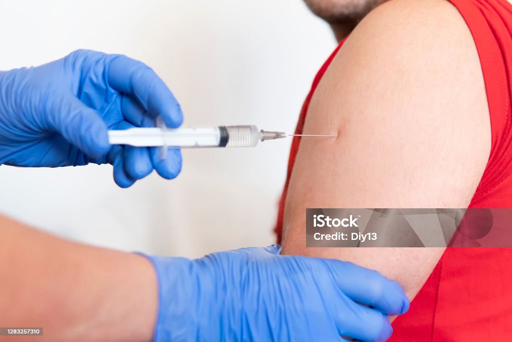 Close-up of doctor making vaccination to the patient on white background, Healthy concept. Prevention of spread of coronavirus infection covid 19 Close-up of doctor making vaccination to the patient on white background, Healthy concept. Prevention of the spread of coronavirus infection covid 19 Deltoid Stock Photo