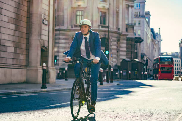 ambientalmente consciente hombre de negocios británico ciclismo para trabajar - front view bus photography day fotografías e imágenes de stock