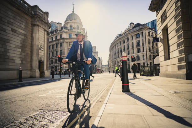 British executive enjoying sunny ride to work by bicycle