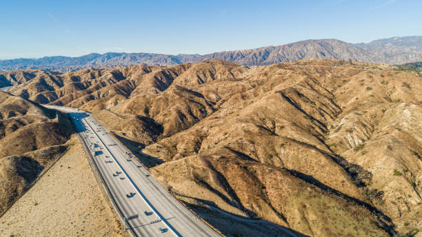 the drone aerial view of the ronald reagan freeway in the california mountains, nearby los angeles and la canada - high desert imagens e fotografias de stock