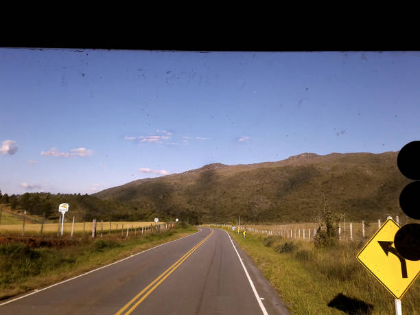 On the road going down the hill with mountains and blue sky in the background