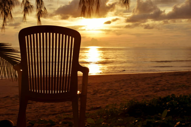 A lone chair on the beach with sunset
