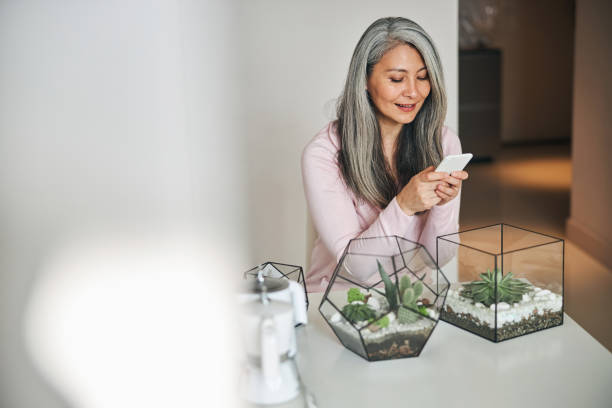 istock Beautiful woman using mobile phone at home 1283267853