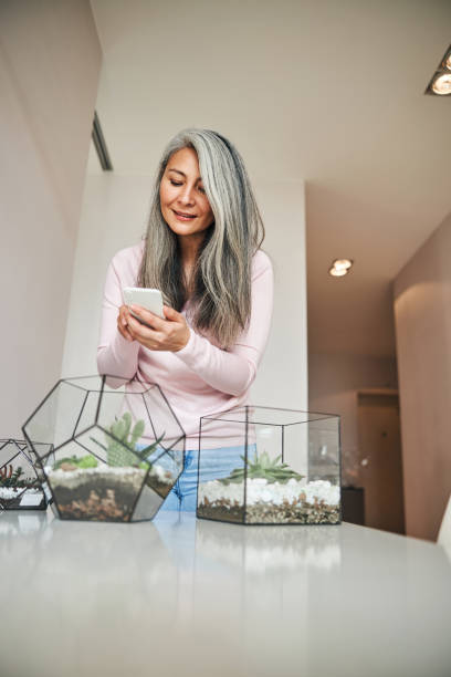 istock Charming woman using modern smartphone at home 1283267858