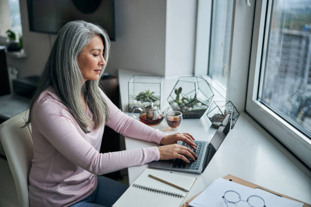 istock Charming woman working on notebook at home 1283267894