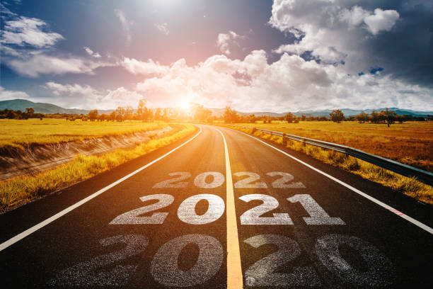 The word 2021 written on highway road in the middle of empty asphalt road golden sunset and beautiful blue sky. Concept for new year 2021. 2021 stock pictures, royalty-free photos & images
