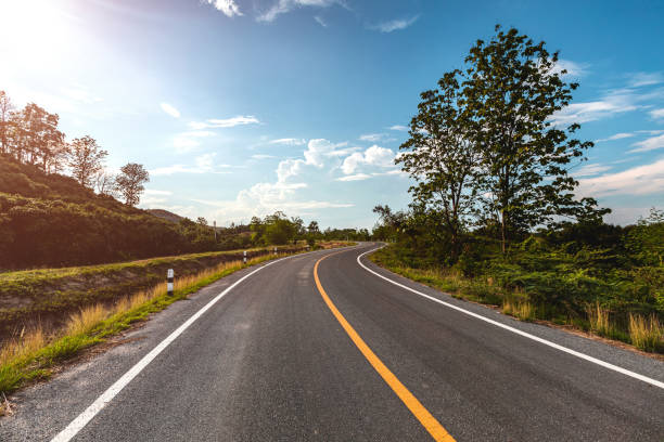 istock Empty highway road through the green field and clouds on blue sky in summer day. 1283271645
