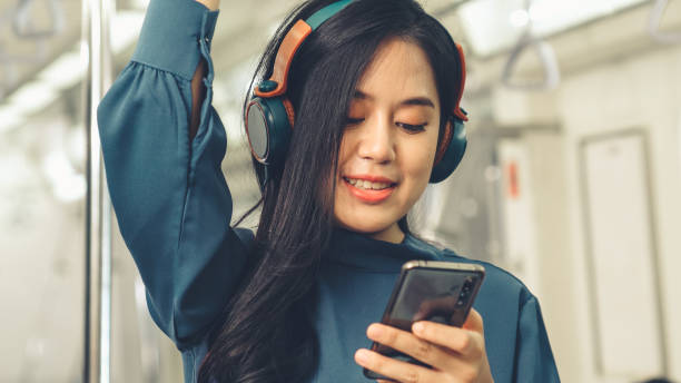 istock Young woman using mobile phone on public train 1283273294