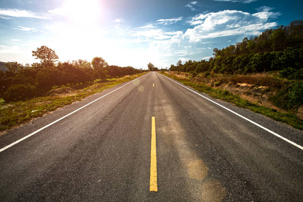 istock Empty highway road through the green field and clouds on blue sky in summer day. 1283275634