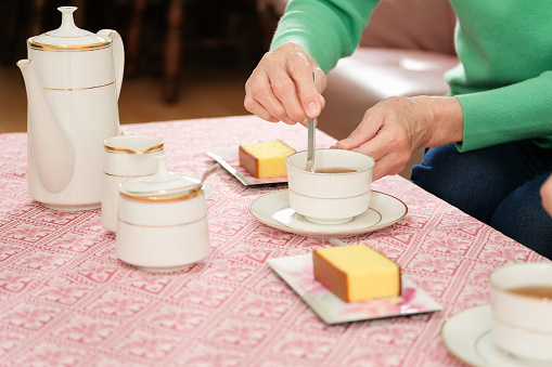 Woman adding sugar to the tea