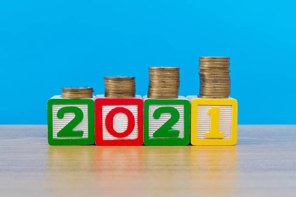 istock 2021 wooden numbers with coins on the table 1283276659