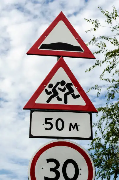 Photo of Group of red and white road signs against dramatic sky.