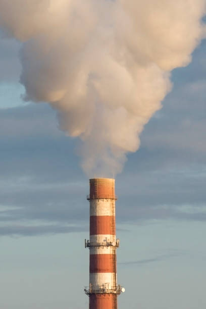 istock Factory smokestack against the blue sky. White smoke close up 1283286573