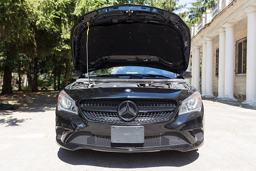 Ozernoe, Zhytomyr region, Ukraine - August 09, 2020: Mercedes-Benz CLA 250 with open hood. The car stands on the street on a sunny day. The car was released in 2015.