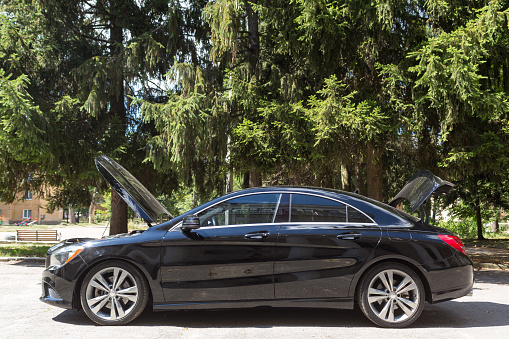 Black limo waiting for bride and groom in front of mansion. Focus on reflection.