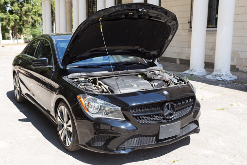 Ozernoe, Zhytomyr region, Ukraine - August 09, 2020: Mercedes-Benz CLA 250 with open hood. The car stands on the street on a sunny day. The car was released in 2015.