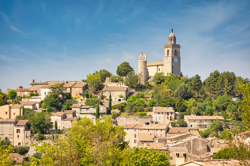 Scenic View to Reillanne Village with Chapelle Saint Denis on the top of the hill in the Parc Naturel Regional du Luberon in Summer under blue sky. Reillanne, Provence Alpes Cote D'Azur, Southern France, France, Europe.